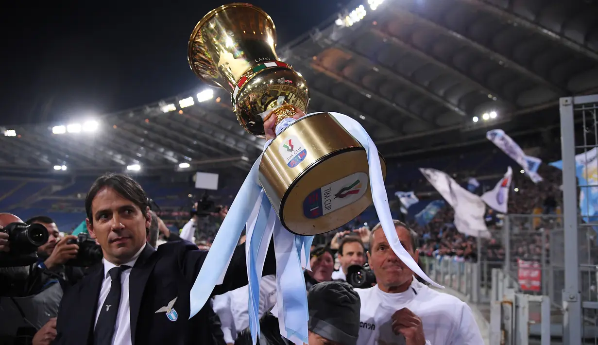 Pelatih Lazio, Simone Inzaghi memegang trofi Coppa Italia saat merayakan kemenangan timnya atas Atlanta pada akhir babak final di Stadio Olimpico, Roma, Rabu (15/5/2019). Lazio keluar sebagai juara Coppa Italia setelah mengalahkan Atalanta 2-0. (REUTERS/Alberto Lingria)
