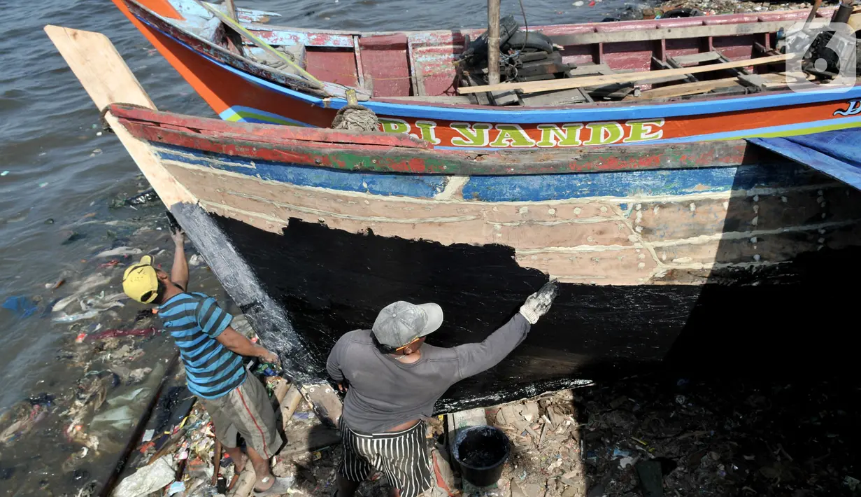 Pekerja menyelesaikan proses perbaikan kapal nelayan di pesisir Marunda, Jakarta, Selasa (22/10/2019). Jasa perbaikan kapal nelayan merupakan salah satu mata pencaharian utama warga pesisir Marunda selain mencari ikan di laut. (merdeka.com/Iqbal Nugroho)