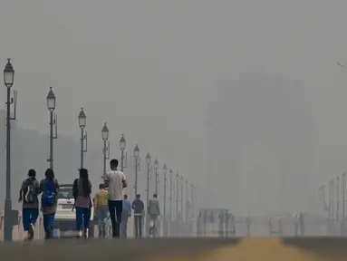 Orang-orang berjalan di sepanjang Jalur Kartavya di dekat Gerbang India di tengah kondisi kabut asap yang tebal di New Delhi pada tanggal 3 November 2023. (ARUN THAKUR/AFP)