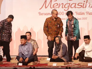 Wapres Jusuf Kalla (tengah) didampingi Ketua Himbara Maryono dan Menteri BUMN Rini M Soemarno dalam acara buka puasa bersama anak yatim di JCC, Jakarta, Kamis (15/06). Kegiatan ini mengundang 3.500 anak yatim.  (Liputan6.com/Fery Pradolo)
