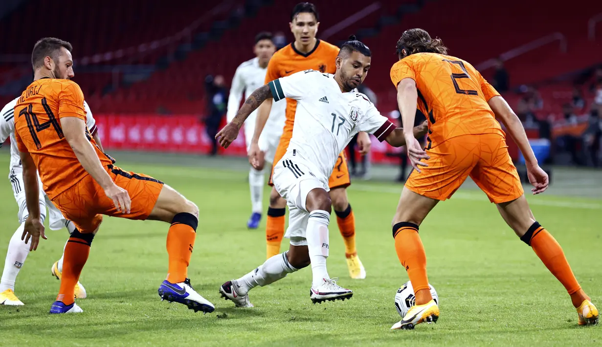 Bek Belanda Stefan de Vrij (kiri) dan Hans Hateboer (kanan) berusaha merebut bola yang dibawa penyerang Meksiko Jesus Manuel (tengah) selama pertandingan persahabatan di Johan Cruyff Arena di Amsterdam (7/10/2020). Meksiko menang 1-0 atas Belanda. (AFP/ANP/Maurice Van Steen)