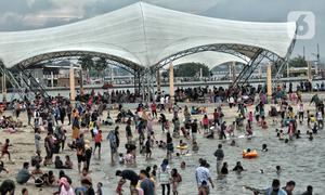 Wisatawan memadati Pantai Ancol saat mengisi libur Natal, Jakarta, Minggu (25/12/2022). Kepala Komunikasi PT Pembangunan Jaya Ancol Ariyadi Eko Nugroho mengungkapkan per hari ini jumlah wisatawan di Taman Impian Jaya Ancol tembus 40.000, angka tersebut meningkat dua kali lipat dibanding libur hari biasa maupun Natal tahun 2021. (merdeka.com/Iqbal S. Nugroho)