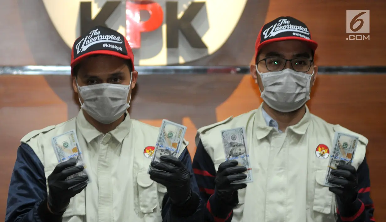 Petugas KPK menunjukkan barang bukti hasil OTT Bupati Muara Enim uang 35.000 dollar AS di Gedung KPK, Jakarta, Selasa (3/9/2019). KPK menahan 4 tersangka terkait suap 6 proyek peningkatan pembangunan jalan di Muara Enim. (merdeka.com/Dwi Narwoko)