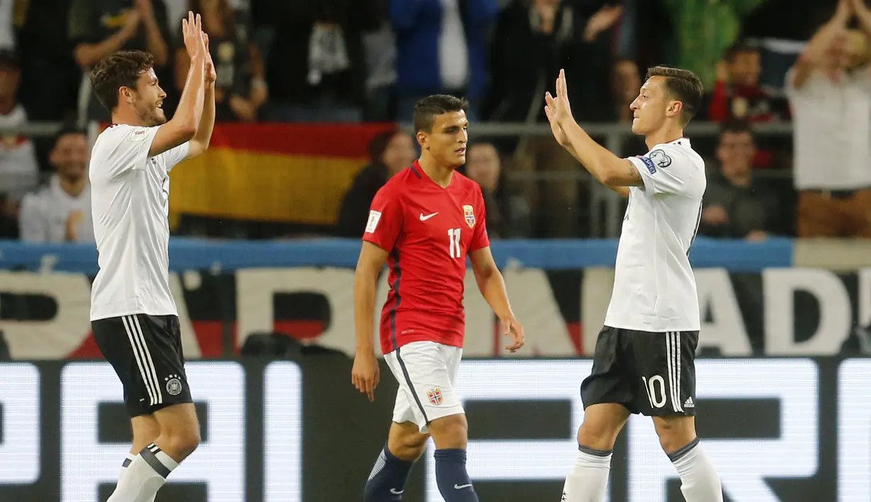 Mesut Ozil (kanan) dan rekannya Jonas Hector merayakan gol saat ke gawang Norwegia pada laga grup C kualifikasi Piala Dunia 2018 di Mercedes-Benz Arena, Stuttgart, (4/9/2017). Jerman menang 6-0. (AP/Michael Probst)