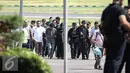 Petugas kepolisian membawa tersangka pembunuhan dan perampokan Pulomas Ridwan Sitorus saat tiba di Bandara Halim Perdana Kusuma, Jakarta, Minggu (1/1). (Liputan6.com/Faizal Fanani)