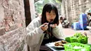 Pengunjung menyantap kuliner cha ruoi di sebuah kios di Hanoi, Vietnam, Jumat (14/12). Cha ruoi dijual dengan harga USD 1. (Manan Vatsyayana/AFP)