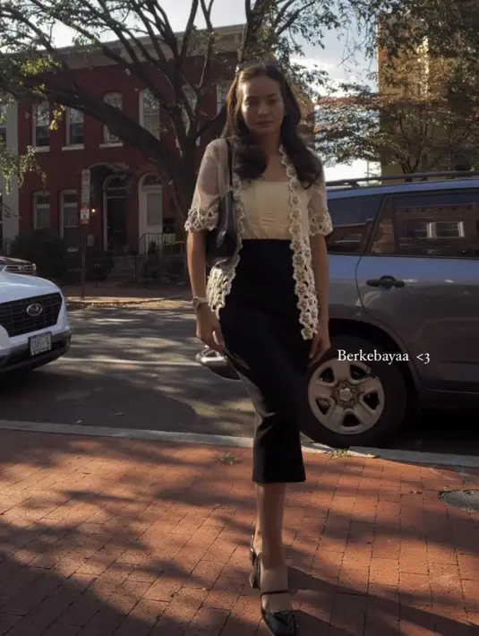 Atasan kebaya tersebut dipadukan skirt span hitam yang serasi dengan shoulder bag dan flat shoesnya. [@enzystoria]