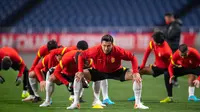 Para pemain China melakukan pemanasan saat mengikuti sesi latihan di Stadion Saitama, Jepang, Rabu (26/1/2022). China akan menghadapi Jepang pada Kualifikasi Piala Dunia 2022 Grup B Zona AFC. (AFP/Philip Fong)