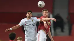 Bek Watford, Adam Masina (kiri) berduel udara dengan gelandang Manchester United, Scott McTominay dalam laga babak ke-3 Piala FA 2020/21 di Old Trafford, Sabtu (9/1/2021). Watford kalah 0-1 dari Manchester United. (AFP/Oli Scarff/Pool)