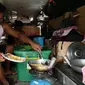 Daniel Flores memasak makan siang di dalam jeepney mereka yang berfungsi sebagai rumah sementara di Manila, 12 Agustus 2020. Angkutan ikonik di Filipina itu belum dapat mengangkut penumpang sejak Maret akibat lockdown Covid-19 yang membuat jutaan orang kehilangan pekerjaan. (Ted ALJIBE/AFP)