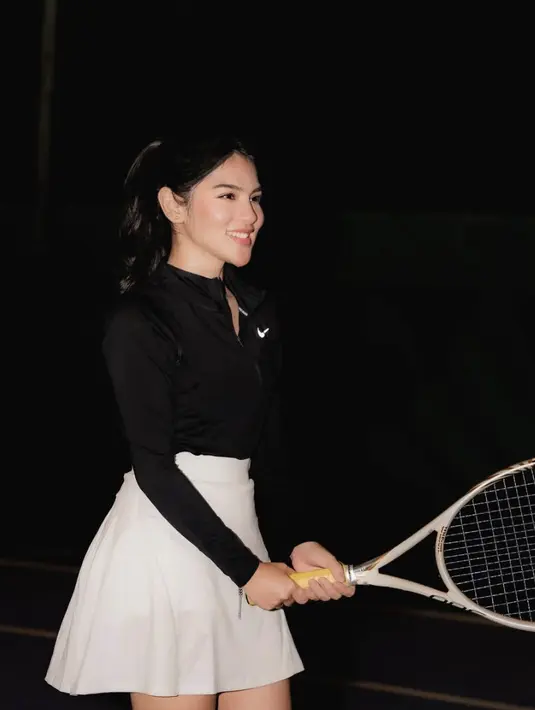 Paduan tenis skirt dan long sleeve berwarna monokrom menambah style gayanya.  [Foto: Instagram/ Davina Karamoy]