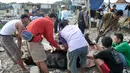 Panitia menguliti hewan kurban yang sudah disembelih di kawasan Kampung Akuarium, Jakarta, Senin (12/9). Ratusan warga korban gusuran Kampung Akuarium Pasar Ikan merayakan Idul Adha 1437 H di antara reruntuhan rumah mereka. (Liputan6.com/Yoppy Renato)
