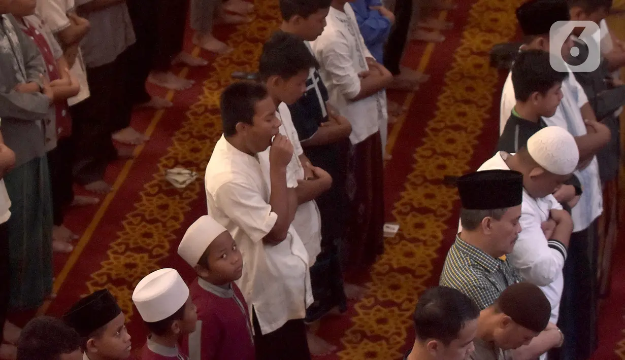Umat Muslim melaksanakan salat Kusuf (salat gerhana matahari) di Masjid Raya Bani Umar, Tangsel, Banten, Kamis (26/12/2019). Sebagian wilayah di Indonesia, pada Kamis (26/12), akan dilintasi gerhana matahari cincin, sejumlah masjid menggelar salat gerhana matahari (Kusuf). (merdeka.com/Arie Basuki)