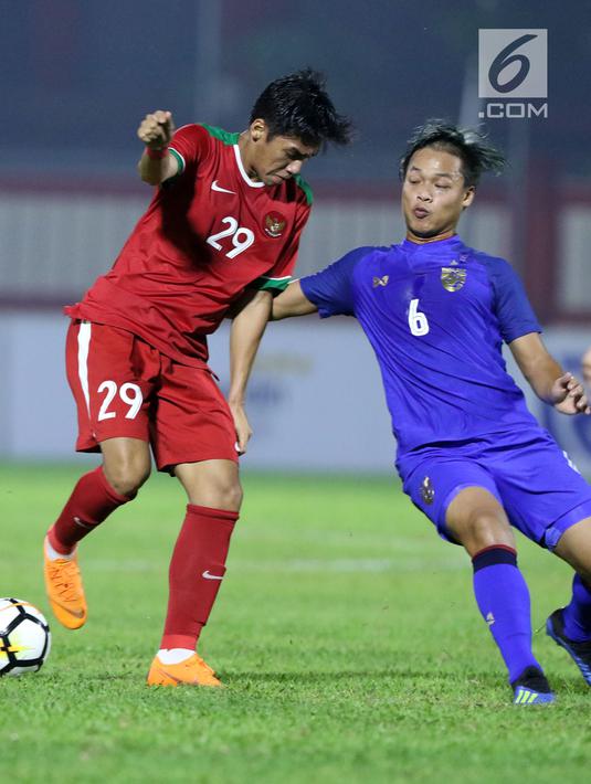 Pemain tengah Timnas Indonesia U-23, Septian David Maulana (kiri) berebut bola dengan pemain Thailand U-23, Sansern Limwatthana pada laga persahabatan di Stadion PTIK, Jakarta, Kamis (31/5). Indonesia U-23 kalah 1-2. (Liputan6.com/Helmi Fithriansyah)
