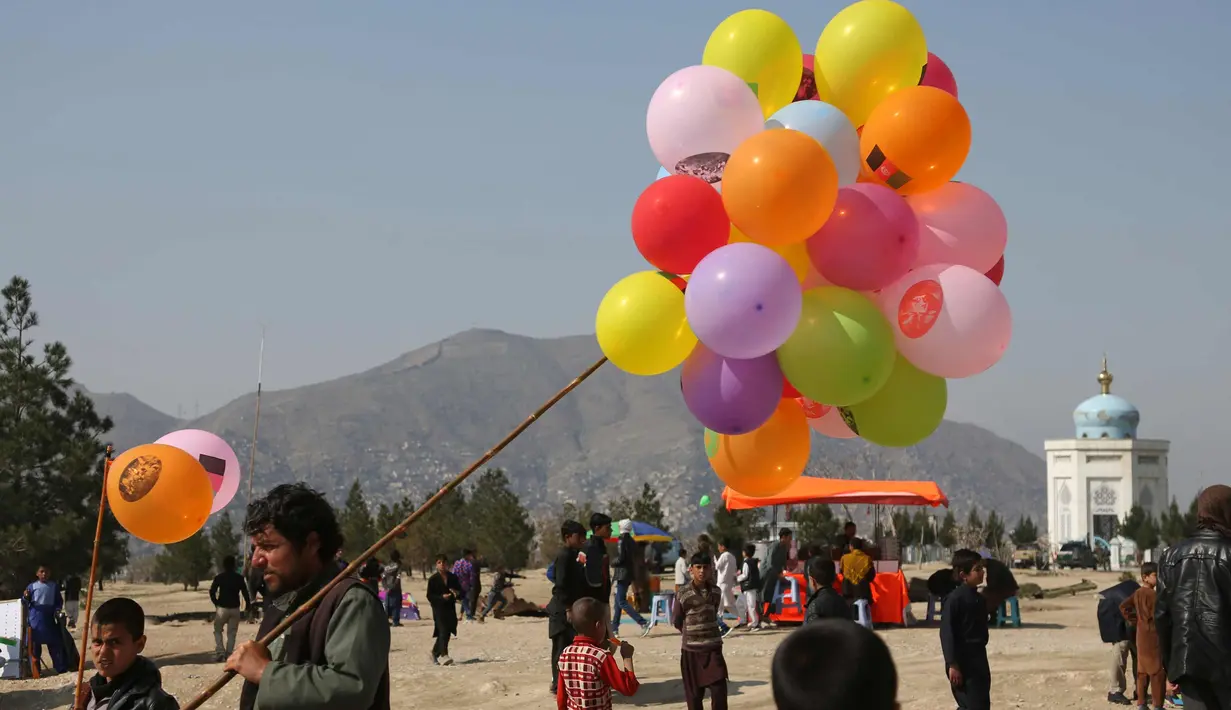 Seorang pria Afghanistan menjual balon selama perayaan untuk Nowruz, Tahun Baru Persia, di Kabul, (21/3). Nowruz dirayakan pada hari pertama musim semi di negara-negara termasuk Afghanistan, Tajikistan, dan Iran. (AP Photo/Rahmat Gul)