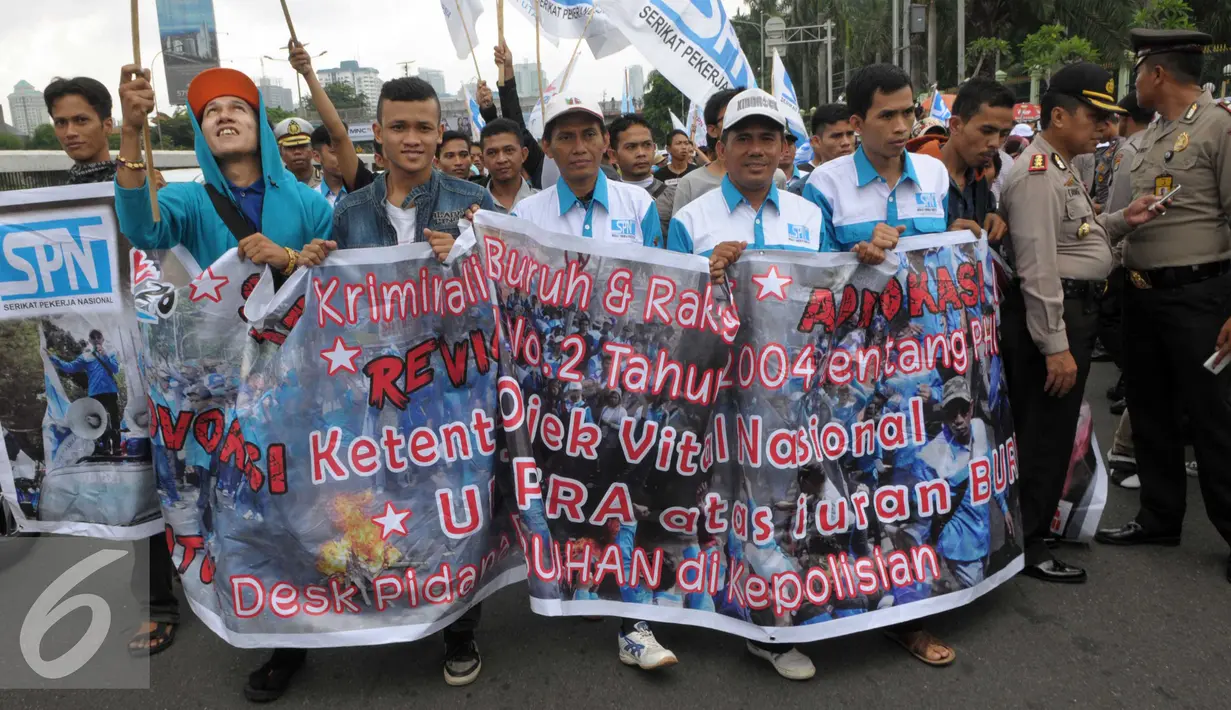 Buruh membawa spanduk saat menggelar aksi May Day di depan gedung DPR, Jakarta, Minggu (1/5). Buruh membawa 12 tuntutan diantaranya menuntut dihapuskannya Sistem Kerja Kontrak dan Outsorcing. (Liputan6.com/Helmi Afandi)