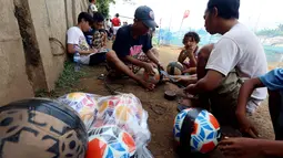 Warga menyiapkan bola untuk bermain dalam kompetisi sepak bola di pinggir Kali Banjir Kanal Barat, Jakarta, Sabtu (5/11). Minimnya sarana bermain sepak bola mengakibatkan warga terpaksa memanfaatkan lahan di pinggir kali. (Liputan6.com/Johan Tallo)