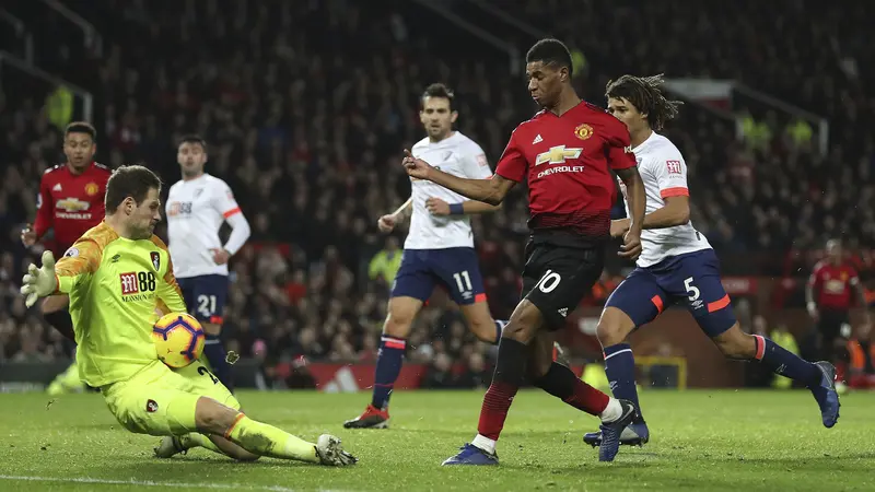 Kiper Bournemouth, Asmir Begovic, menghalau tendangan striker Manchester United, Marcus Rashford, pada laga Premier League di Stadion Old Trafford, Manchester, Minggu (30/12). MU menang 4-1 atas Bournemouth. (AP/Martin Rickett)