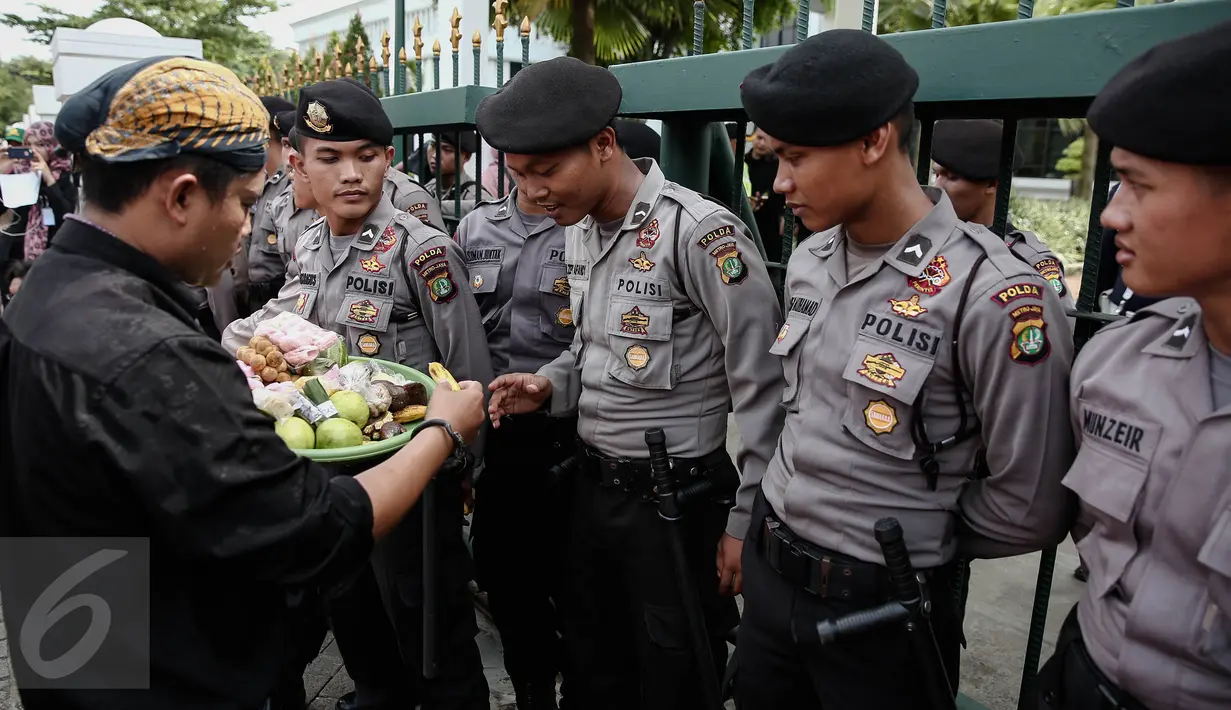 Sejumlah polisi diberikan makanan oleh peserta aksi di depan Mahkamah Agung, Jakarta, Kamis (2/6/2016). Massa dari Koalisi Lawan Perampasan Tanah menggelar unjuk rasa menuntut penyelesaian konflik Agraria. (Liputan6.com/Faizal Fanani)