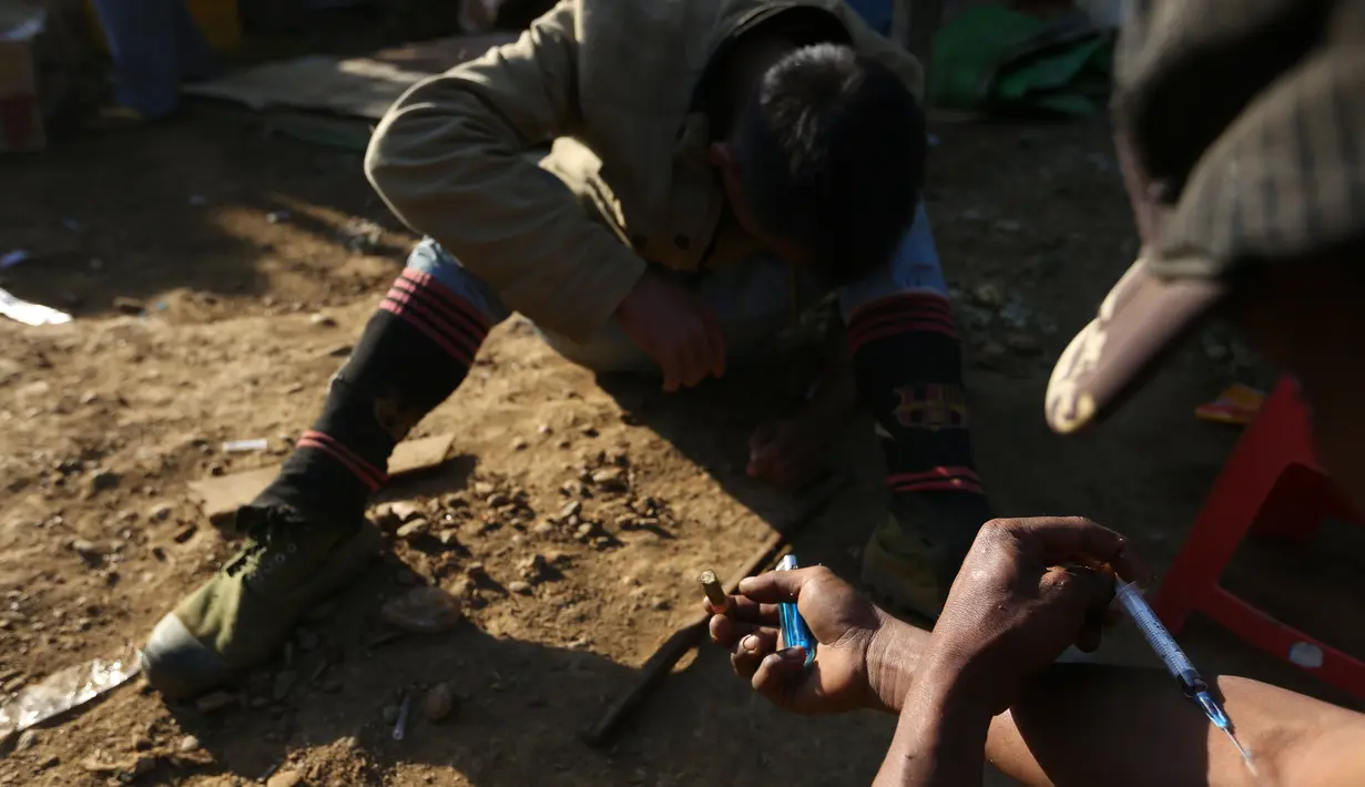 Dua penambang menyuntikkan heroin di Tambang batu giok di Hpakant, Myanmar, 29 November 2015. Kecanduan narkotika sudah merabak pada penambang batu giok untuk digunakan dengan alasan agar kuat mencari & menemukan gumpalan batu mulia (REUTERS/Soe Zeya Tun)
