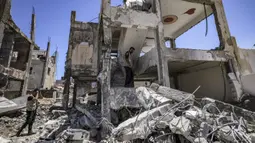 Pakar bahan peledak Hamas mencari proyektil yang tidak meledak dari reruntuhan bangunan setelah konflik Mei 2021 dengan Israel di Kota Gaza, Sabtu (5/6/2021). Perang 11 hari antara Hamas dan Israel menewaskan 254 orang Palestina dan 12 orang Israel. (MAHMUD HAMS/AFP)
