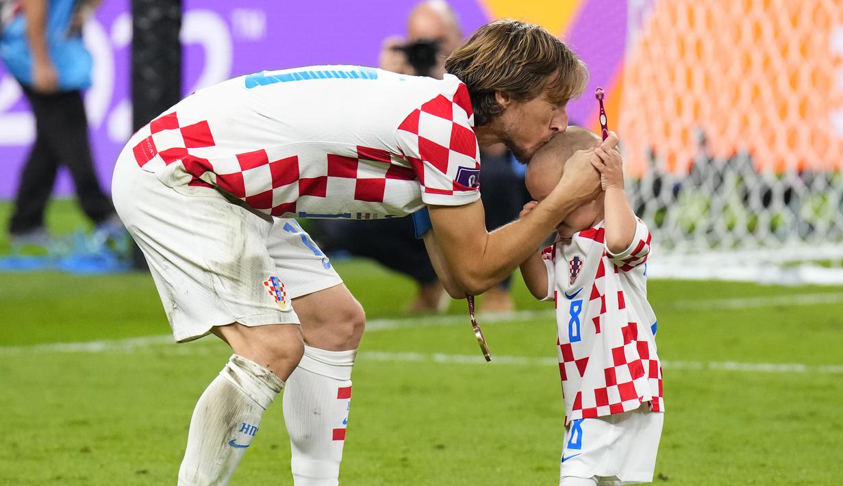 Bukan hanya merayakan kebahagian dengan anaknya sendiri, Luka Modric juga memberikan ciuman hangat kepada Ivan yang merupakan anak dari Moteo Kovacic. (AP Photo/Hassan Ammar)