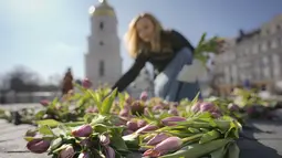Seorang wanita menata bunga tulip di alun-alun Sophia di Kiev, Ukraina (18/3/2022). Warga Kiev turun ke alun-alun pusat untuk menata sekitar 1,5 juta bunga tulip bentuk lambang negara dalam pertunjukan normal yang menantang saat pasukan Rusia mengepung dan mengebom kota. (AP Photo/Vadim Ghirda)