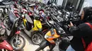 Awak media mengambil gambar motor yang dikendarai Adi Saputra (21) di Polres Tangerang Selatan, Jumat (8/2).  Adi Saputra merusak motor matik-nya lantaran tidak terima ditilang polisi di kawasan BSD pada Kamis (7/2) kemarin. (Liputan6.com/Herman Zakharia)