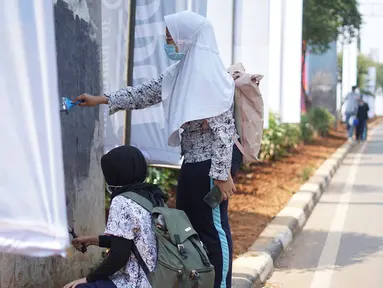 Pelajar mengecat  coretan yang mengotori tembok  saat kericuhan dalam unjuk rasa di Senayan, Jakarta, Jumat (4/10/2019). Para siswa dan alumni SMA menutup coret-coretan  itu sekaligus mengampanyekan cinta damai dalam praktik demokrasi di Indonesia. (Liputan6.com/Immanuel Antonius)