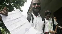 Siswa SMAN 1 Timika Papua menunjukan bukti kelulusan usai pengumuman hasil ujian nasional, Senin (15/6). Lima dari 196 peserta UN dinyatakan tidak lulus. (antara)