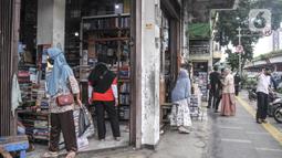 Suasana penjual buku pelajaran sekolah di Pasar Buku Kwitang, Jalan Kramat Raya, Kecamatan Senen, Jakarta Pusat, Minggu (17/7/2022). Kembali diberlakukkannya pembelajaran tatap muka (PTM)membuat penjualan buku sekolah di Pasar Buku Kwitang mengalami peningkatan hingga 60 persen . (merdeka.com/Iqbal S Nugroho)