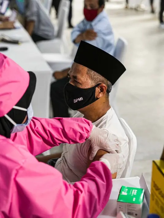 Petugas kesehatan menyuntikan vaksin COVID-19 kepada seorang pemuka agama di Mesjid Istiqlal, Jakarta, Selasa (23/2/2021). Pemuka agama yang mengikuti vaksinasi ini mencapai ribuan orang. (Liputan6.com/Faizal Fanani)