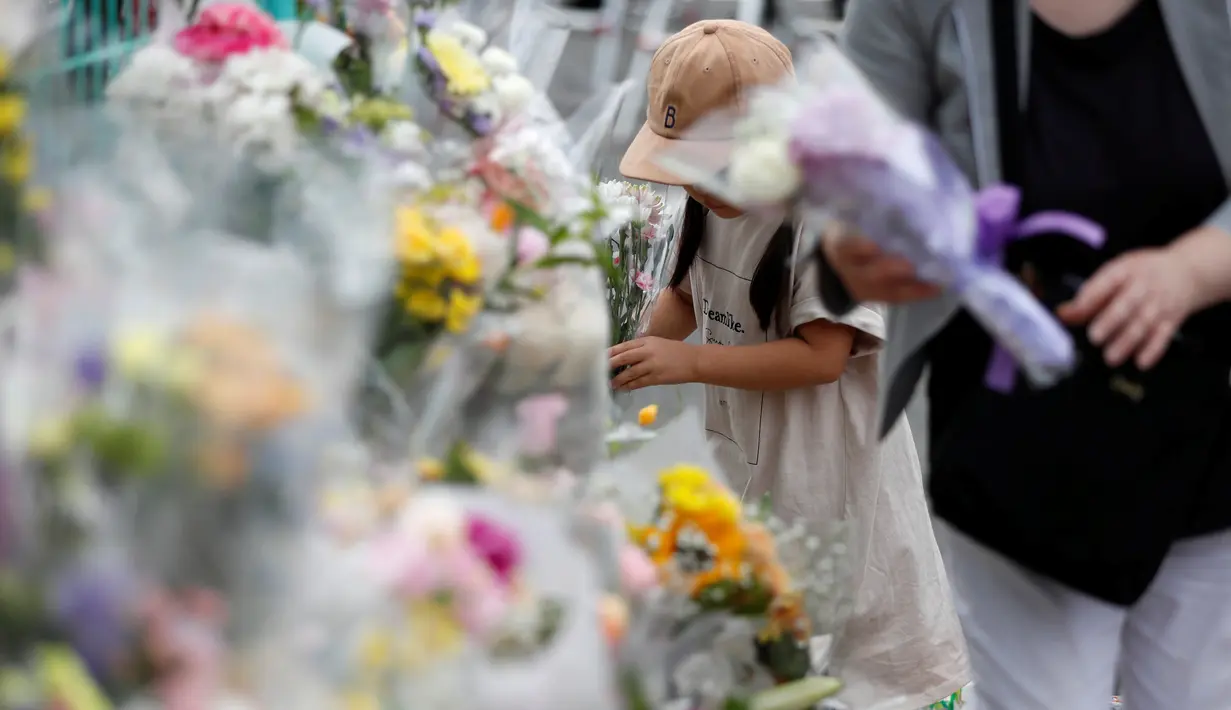 Seorang gadis manaruh bunga untuk untuk korban Penikaman Massal yang terjadi di Kawasaki, Jepang (29/5/2019). PM Jepang, Shinzo Abe, menyatakan kemarahan atas penikaman massal di Kawasaki yang juga melukai belasan siswa Sekolah Dasar (SD) ini. (Reuters/Issei Kato)