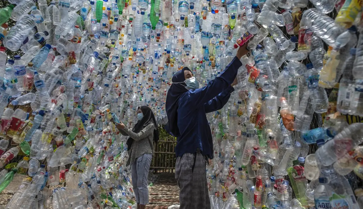 Aktivis Ecological Observation and Wetland Conservation (Ecoton) membuat instalasi yang terbuat dari sampah plastik di Gresik, Jawa Timur, 17 September 2021. Instalasi tersebut untuk meningkatkan kesadaran masyarakat akan sampah plastik di sungai dan lautan. (JUNI KRISWANTO/AFP)