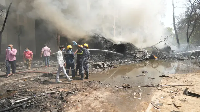 Petugas Pemadam dan Penyelamat Berjbaku di Lokasi Jatuhnya Pesawat Air India