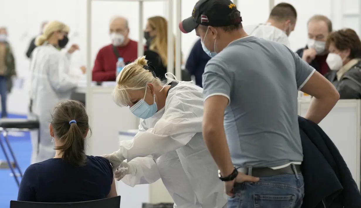 Seorang pria melihat wanita dari Rusia disuntik vaksin COVID-19 di Zagreb, Kroasia, pada 9 November 2021. Kroasia telah menjadi tempat favorit baru bagi warga Rusia yang mencari vaksin produksi Barat karena Sputnik V buatan Negeri Beruang Putih itu belum disetujui oleh WHO. (AP Photo/Darko Bandic)