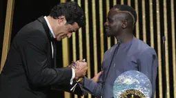 Penghargaan tersebut diserahkan langsung oleh Rai (kiri), mantan pemain timnas Brasil dan Paris Saint-Germain. Rai juga merupakan adik laki-laki Socrates, pesepakbola yang juga terlibat dalam aksi sosial di Brasil. (AP/Francois Mori)