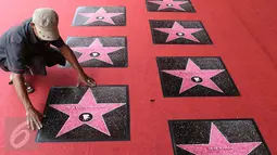 Petugas saat memasang prasasti berbentuk bintang (walk of fame) jelang perhelatan malam puncak Festival Film Bandung (FFB) 2015 di Monumen Perjuangan Rakyat, Bandung, Sabtu (12/9/2015). (Liputan6.com/Herman Zakharia)