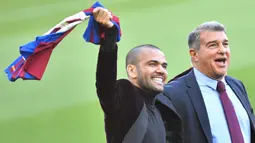 Dani Alves menyita perhatian saat sesi perkenalan sebagai pemain baru Barcelona. Ditemani Joan laporta, Alves tampak menggunakan sandal jepit saat memasuki stadion Camp Nou. Hal tersebut mirip kala dirinya mendarat untuk pertama kalinya pada 13 tahun silam. (AFP/Pau Barrena)