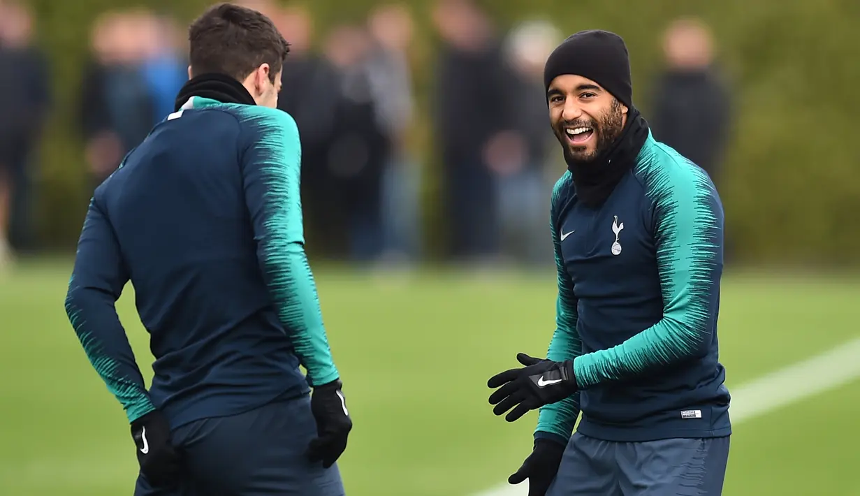 Gelandang Tottenham Hotspur, Lucas Moura tertawa saat sesi latihan di Pusat Pelatihan Enfield, London utara (12/2). Tottenham akan bertanding melawan Borrusia Dortmund pada 16 besar Liga Champions di stadion Wambley. (AFP Photo/Glyn Kirk)