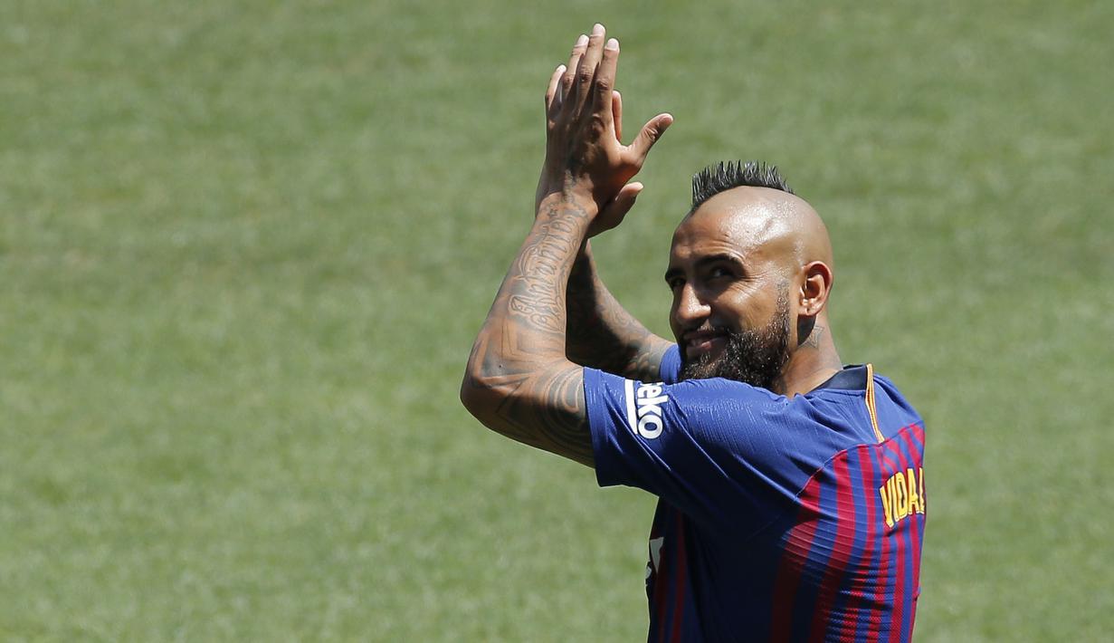 Pemain baru Barcelona, Arturo Vidal, menyapa fans saat perkenalan di Stadion Camp Nou, Senin, (7/8/2018). Barcelona merogoh kocek sebesar 19 juta euro untuk mengamankan jasa pria berkebangsaan Cile itu. (AP/Manu Fernandez)