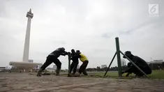 Petugas Unit Pengelola Kawasan (UPK) Monas mencopot pagar pembatas antara jalan dengan taman di kawasan Monas, Jakarta, Jumat (11/1). Pencabutan pagar itu merupakan arahan langsung dari Wakil Gubernur DKI Sandiaga Uno. (Liputan6.com/Arya Manggala)