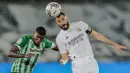 Striker Real Madrid, Karim Benzema (kanan) berduel udara dengan bek Real Betis, Emerson dalam laga lanjutan Liga Spanyol 2020/2021 pekan ke-33 di Alfredo Di Stefano Stadium, Madrid, Sabtu (24/4/2021). Real Madrid bermain imbang 0-0 dengan Real Betis. (AP/Bernat Armangue)