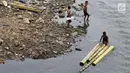 Anak-anak berenang menggunakan batang pohon pisang di bantaran Sungai Ciliwung, Jakarta, Selasa (15/5). Aktivitas tersebut berbahaya bagi kesehatan dan keselamatan mereka. (Liputan6.com/Immanuel Antonius)