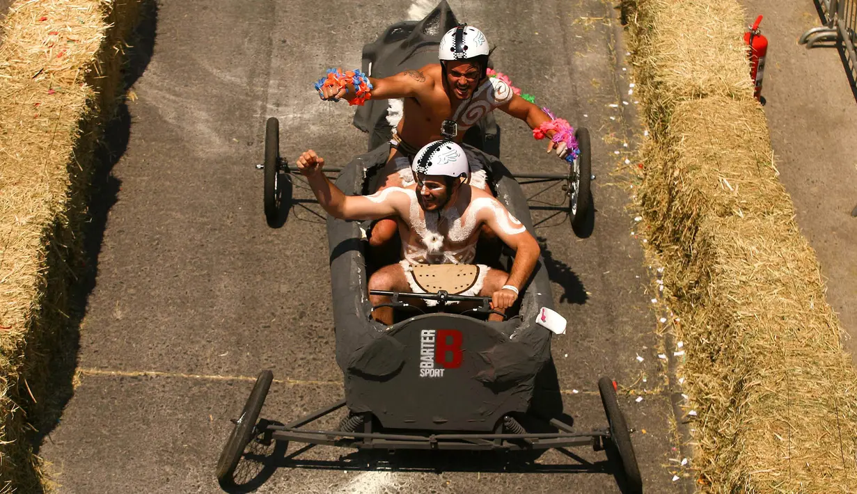 Peserta melintasi jalanan menurun dalam ajang balap mobil 'Kotak sabun' Red Bull Soapbox di Santiago, Chili, Minggu (27/11). Para pengemudi mengandalkan gaya gravitasi bumi karena kendaraan mereka tidak memiliki mesin. (REUTERS/Jonathan Faus)