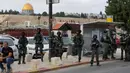 Masjid Kubah Batu terlihat di belakang pasukan keamanan Israel yang berjaga-jaga saat umat Islam Palestina berkumpul untuk salat Jumat di Yerusalem timur pada 29 Desember 2023. (AHMAD GHARABLI/AFP)