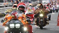 Sejumlah pengendara motor gede mengenakan kostum Santa Claus dan rusa di kota Tokyo, Jepang, (23/12). Touring ini dinamakan "Toy Run" yang diselenggarakan oleh komunitas Harley Santa Club. (AFP PHOTO/Toru Yamanaka)