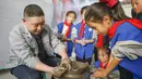 Sejumlah siswa sekolah dasar mencoba membuat porselen di bengkel kerja porselen Ru di Baofeng, Provinsi Henan, China, 15 November 2020. Baofeng dikenal sebagai produsen porselen Ru, satu dari lima porselen yang tersohor selama era Dinasti Song (960-1279) pada zaman China kuno. (Xinhua/He Wuchang)