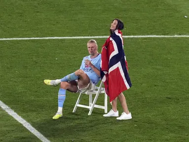 Pemain Manchester City Erling Haaland tersenyum saat duduk di lapangan setelah memenangkan pertandingan sepak bola final Liga Champions antara Manchester City dan Inter Milan di Stadion Olimpiade Ataturk, Istanbul, Turki, Minggu (11/6/2023). (AP Photo/Thanassis Stavrakis)