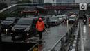 Petugas berjalan di antara kendaraan yang terjebak kemacetan di ruas Tol Dalam Kota (Dalkot), Jakarta, Selasa (17/12/2019). Air hujan sempat menggenangi sebagian ruas Tol Dalam Kota  untuk arah Kuningan arah Cawang hingga sempat membuat lalu lintas tersendat. (Liputan6.com/Faizal Fanani)